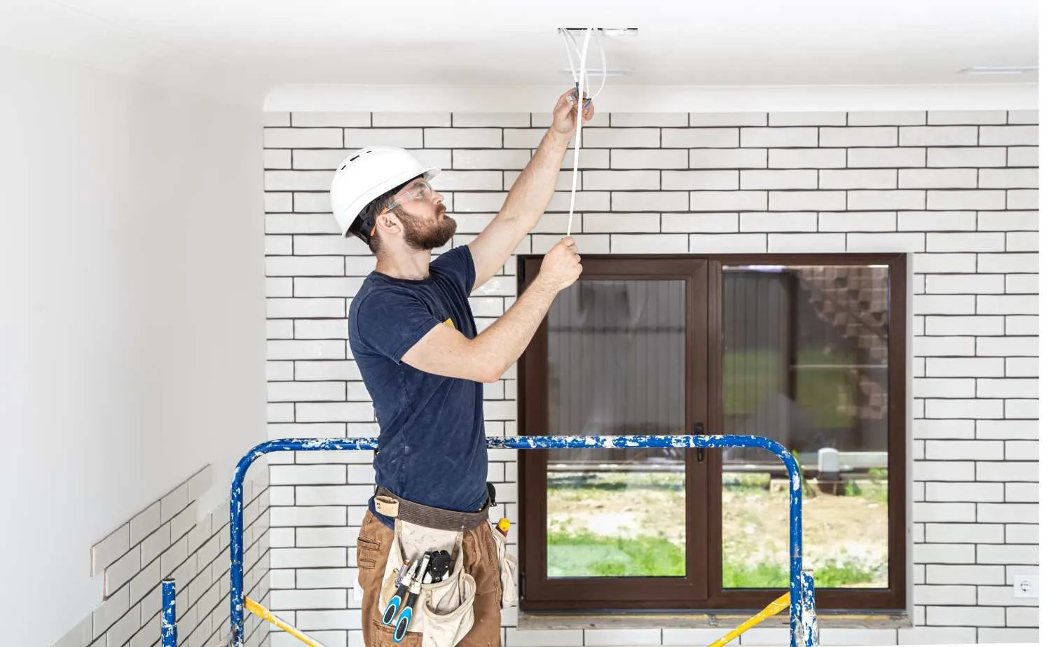 Electrician running wires through a ceiling