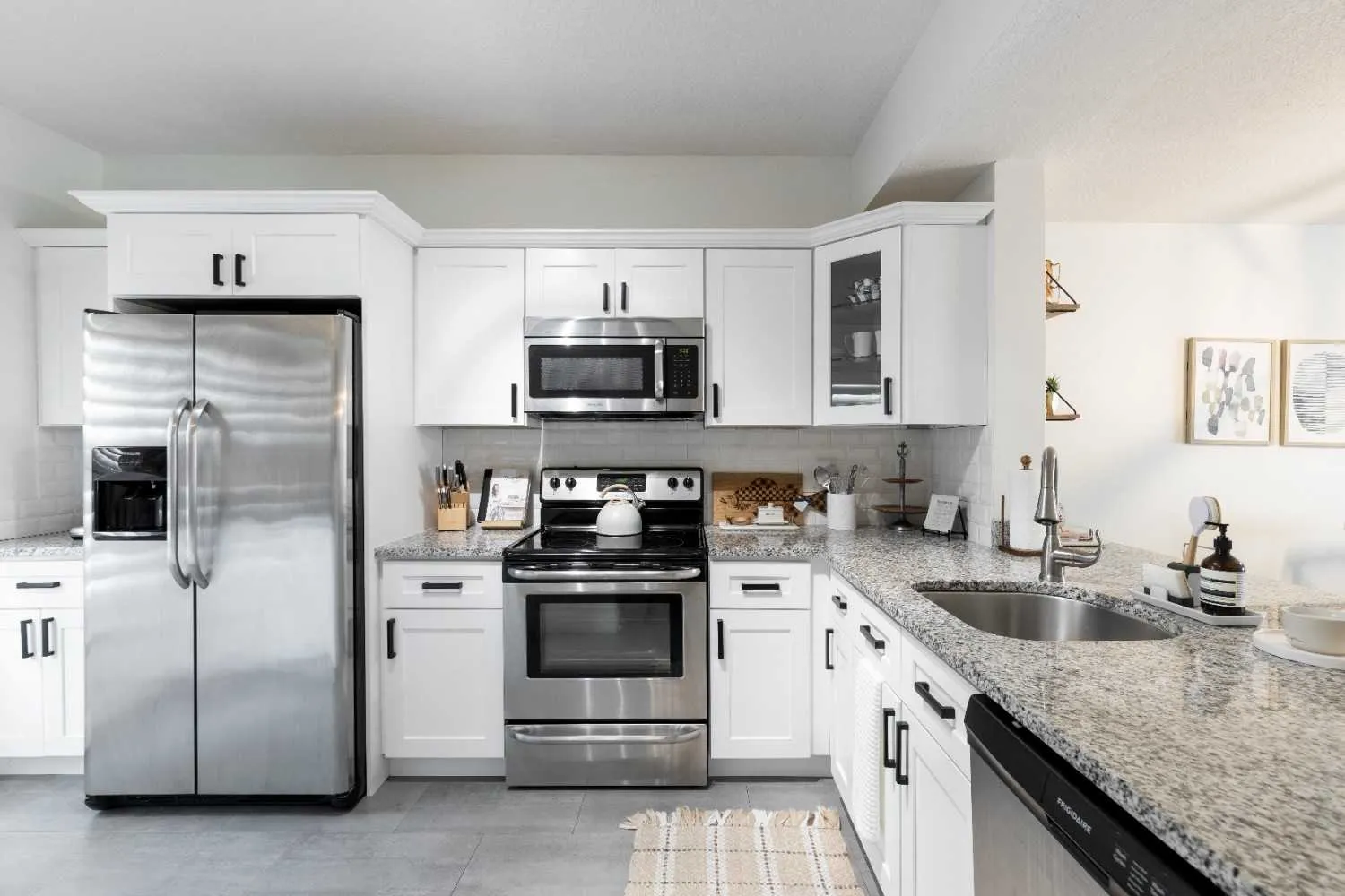 White kitchen with a fridge, range and microwave
